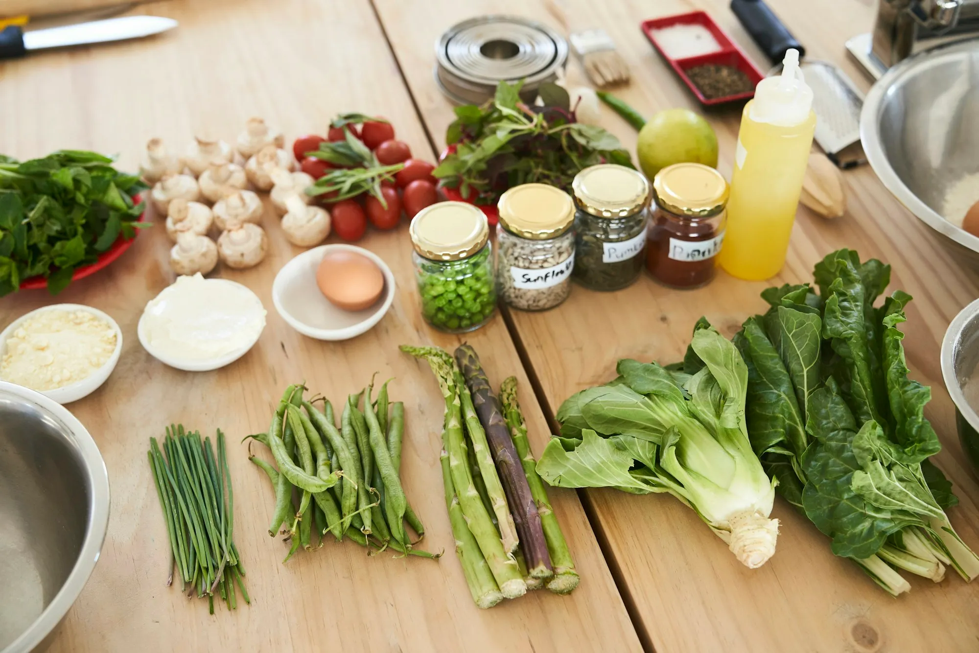 Mesa de madeira com verduras, legumes, cogumelos e temperos frescos